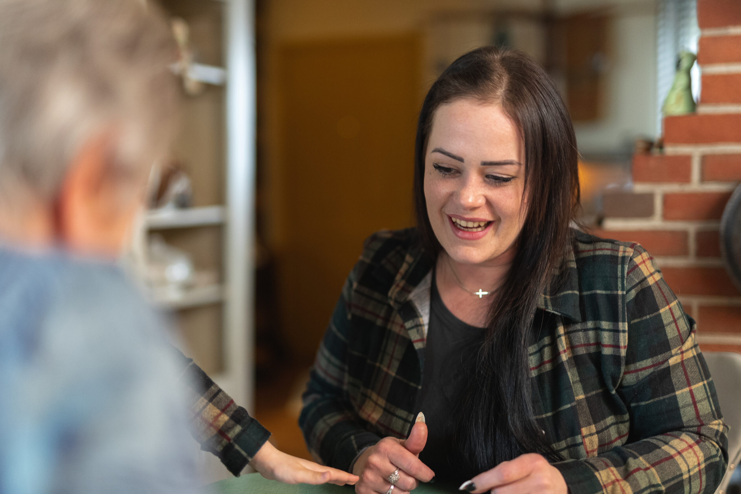 Abbey sitting at a table talking with Neighboring Volunteers
